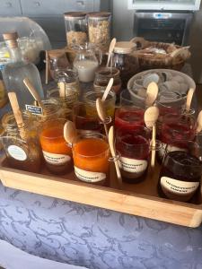 a tray filled with jars and spoons on a table at Maison d'hôtes Bastide St Victor à 2,5 kilomètres de Lourmarin in Puyvert
