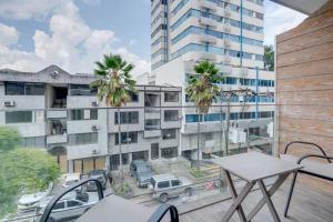 a balcony with a table and a view of a building at Leb'Den Executive Suites in Cali