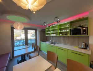 a kitchen with green cabinets and a table and chairs at Asenata Pokoje&Apartamenty Ustroń Centrum in Ustroń