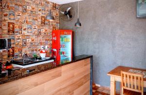 a red refrigerator in a kitchen with a table at Flats e suítes Alegria in Olímpia