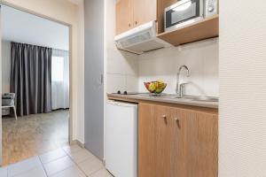 a small kitchen with a sink and a microwave at Appart'City Confort Amiens Gare in Amiens +27 photos