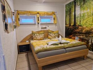 a bedroom with a bed with a painting on the wall at Ferienwohnung Am Öpitzer Berg in Pößneck