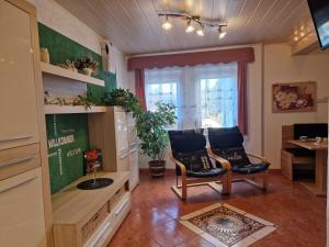 a living room with two chairs and a table at Ferienwohnung Am Öpitzer Berg in Pößneck