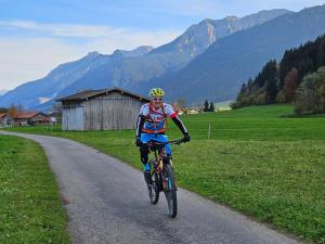 a man riding a bike down a road at Ferienwohnung Bergherz in Sankt Johann im Walde