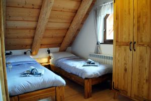 two twin beds in a room with wooden ceilings at Penzión NOVA in Spišská Stará Ves +62 photos