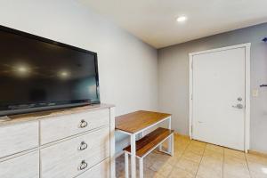 a living room with a flat screen tv on a dresser at Sea Treasures Inn #102 in Rockaway Beach