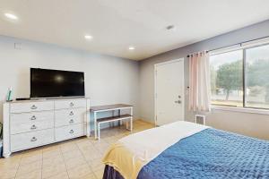 a bedroom with a bed and a flat screen tv at Sea Treasures Inn #102 in Rockaway Beach