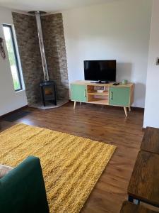 a living room with a flat screen tv on a wooden floor at Los Ciruelos Cabin in Calbuco