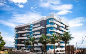 a building with palm trees in front of it at Three bedroom place with lake view in Kampala