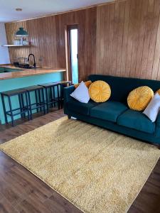 a blue couch sitting in a living room with a rug at Los Ciruelos Cabin in Calbuco