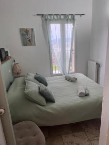 a bedroom with a bed with pillows and a window at Maison d'hôtes Bastide St Victor à 2,5 kilomètres de Lourmarin in Puyvert