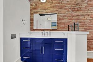 a bathroom with a blue and white sink and a brick wall at Luxe 220 Suite 4 in Wilmington +39 photos