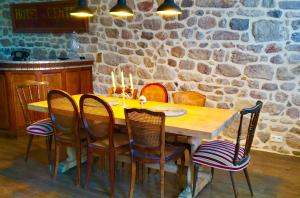 a wooden table with chairs and a stone wall at Monsieur Morgan's in Féniers
