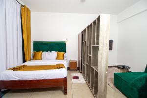 a bedroom with a bed and a book shelf at MIG Studios in Nakuru +64 photos