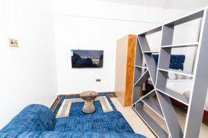 a room with a blue couch and a bunk bed at MIG Studios in Nakuru