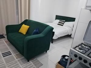 a living room with a green couch and a bed at Magenche in Ongata Rongai 