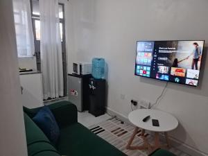 a living room with a green couch and a tv at Magenche in Ongata Rongai  +5 photos