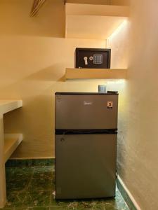 a small refrigerator in a room with a shelf at The FLORENTHINA'S House in Oaxaca City