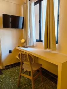 a desk with a chair in front of a window at The FLORENTHINA'S House in Oaxaca City