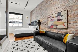 a living room with a couch and a brick wall at Luxe 220 Suite 5 in Wilmington