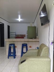 a living room with a couch and two blue stools at Apartamentos GoZu # 2 in Puerto Viejo