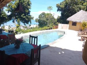 a view of a swimming pool with a table and a table at Colibri Lodge in Ambatoloaka