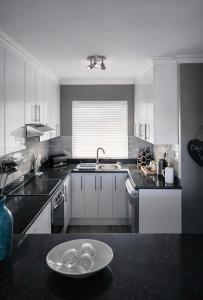 a kitchen with white cabinets and a plate on the counter at Deja View in Knysna