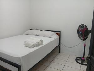 a bedroom with a bed with two pillows and a fan at Apartamentos GoZu # 2 in Puerto Viejo +1 photo