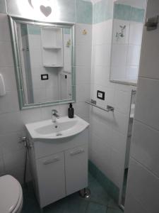 a bathroom with a sink and a mirror and a toilet at House Le Antiche Mura in Castel Volturno +28 photos