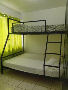 two bunk beds in a room with white sheets at Apartamentos GoZu # 2 in Puerto Viejo