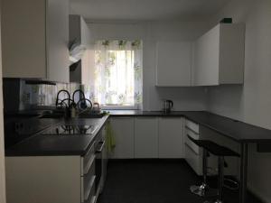 a kitchen with white cabinets and a black counter top at Stadtmitte Ferienwohnung in Darmstadt