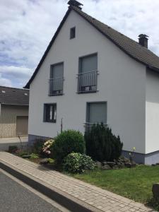 a white house with balconies on a street at Ferienhaus Vogelsberg in Mechernich