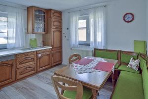a kitchen with a wooden table and green chairs at Ferienhaus Vogelsberg in Mechernich