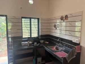 a kitchen with a sink and a counter top at Athityam Home Stay in Honāvar