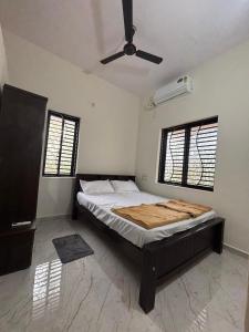 a bedroom with a bed and a ceiling fan at Athityam Home Stay in Honāvar