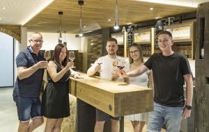 a group of people standing around a bar holding wine glasses at Weingut Gästehaus D&D Haider in Jois