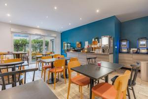 a restaurant with tables and chairs and a kitchen at Appart'City Classic Lyon Part Dieu Garibaldi in Lyon