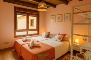 a bedroom with two beds and a window at Casa Maldivas - Cerca playa de Barro/ Niembro in Posada de Llanes