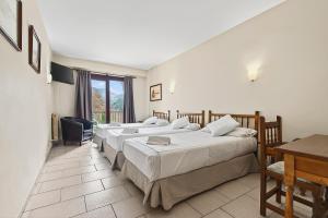 a hotel room with three beds and a table at Hotel Xalet Besolí in Arinsal +45 photos