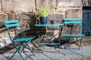 two chairs and a table with a potted plant on it at Apartment 23 - zentrumsnah - Parkplatz in Coburg +1 photo