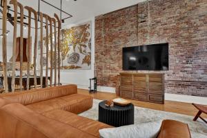 a living room with a couch and a brick wall at Luxe 220 Suite 6 in Wilmington