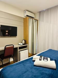 a hotel room with a bed with two remote controls on it at Gaivotas Praia Hotel in Florianópolis