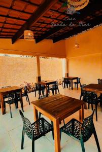 a group of tables and chairs in a restaurant at Pousada casa sonho do mar in Fortim