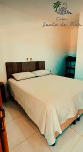 a bedroom with a white bed with a sign on the wall at Pousada casa sonho do mar in Fortim