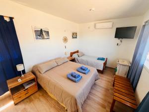 a small bedroom with two beds and a television at El Atardecer Monoambiente in Puerto Pirámides