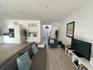 a living room with a couch and a flat screen tv at DuMar Beachouse in Salema