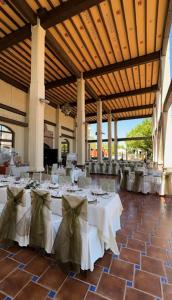 a banquet hall with white tables with bows on them at Hotel Castillo de Montemayor in Montemayor