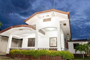 a white house with a window and plants at Casa Mutya in Dauis