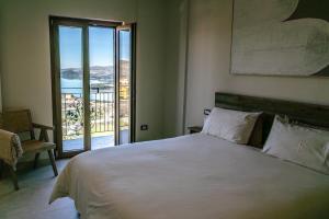 a bedroom with a large white bed and a balcony at B&B Il Belvedere 2 in Guardialfiera