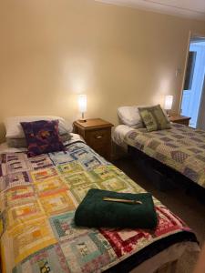 a bedroom with two beds and a green bag on a bed at The Wright Place To stay in East Harling